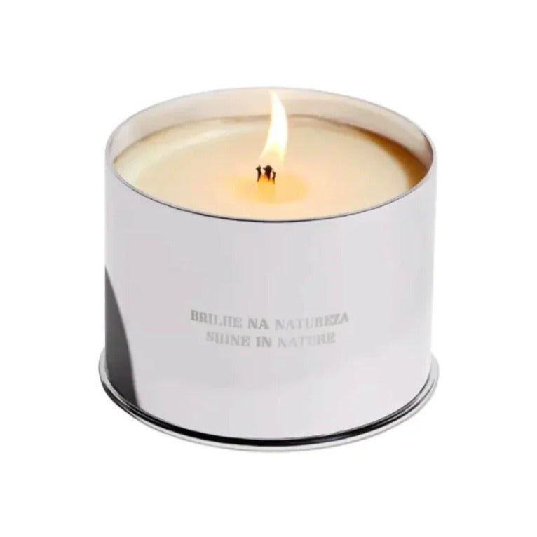 Lit candle in a polished silver tin engraved with 'Shine in Nature', available at ställe studios