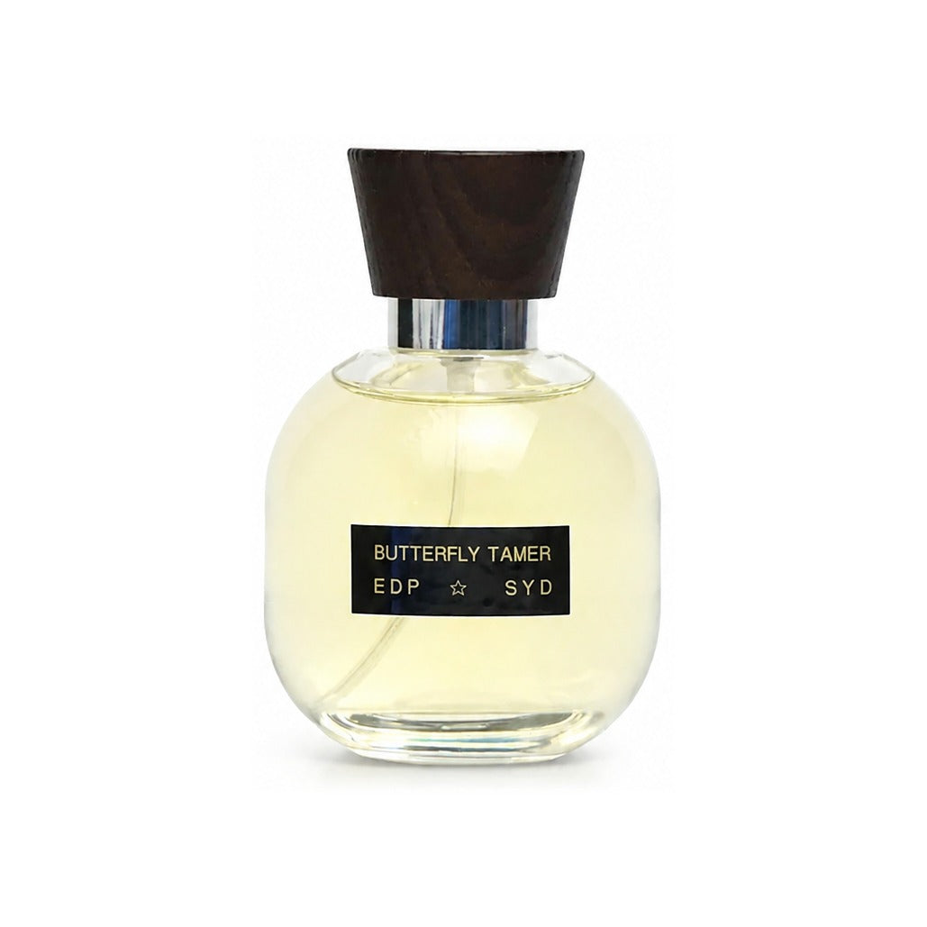 Syd Botanica Butterfly Tamer EDP in a rounded glass bottle with dark wood cap and black label