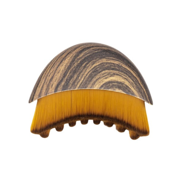 The Lymphatic Brush Face with wood-grain dome handle and soft amber bristles for facial lymphatic drainage